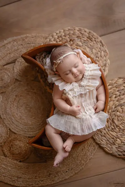 Baby in der Holzschale – liebevolles Babyfoto