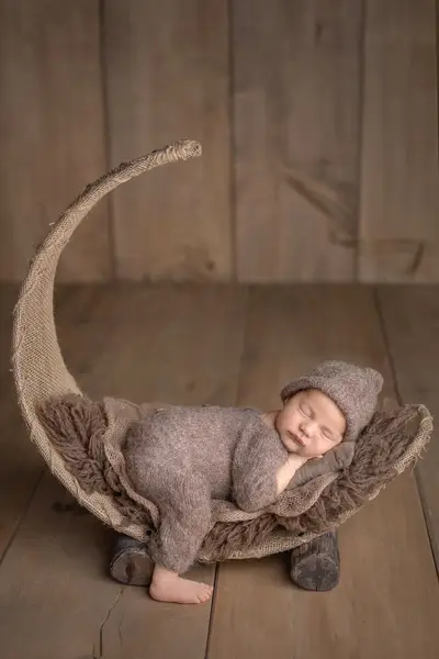 Neugeborenes in einer Holzschale – klassische Newborn-Pose
