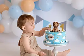 Baby beim Cake Smash Shooting mit Torte und Ballons