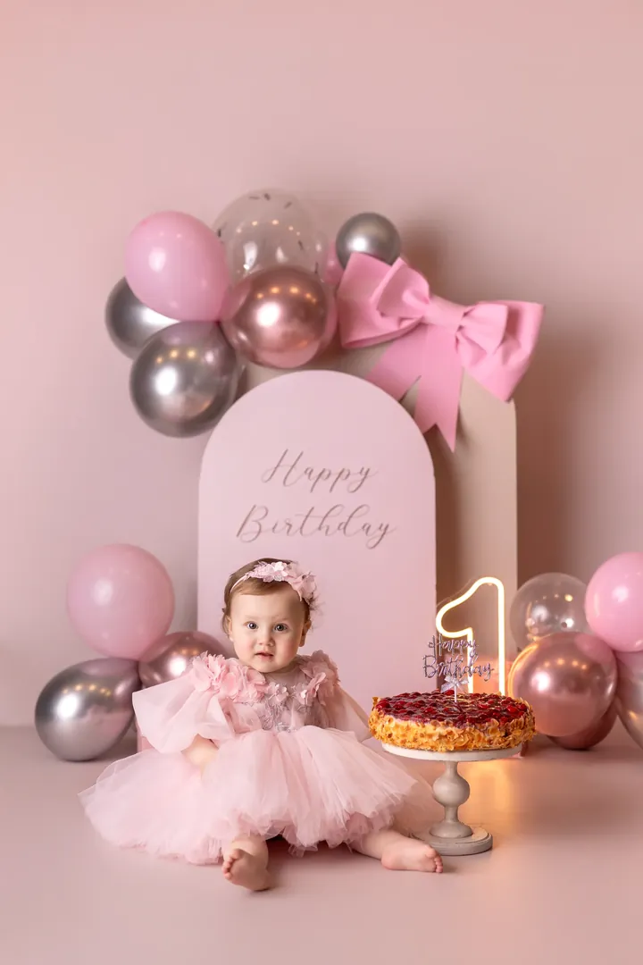 Einjähriges Mädchen im rosa Tüllkleid beim Cake Smash zum ersten Geburtstag
