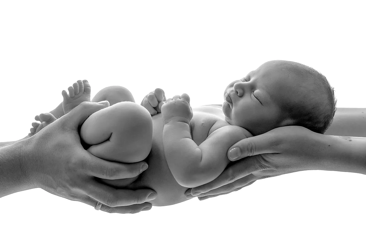 Neugeborenenfoto – Baby kuschelt sich in Decke